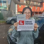 Newly qualified driver beside a Drive Croydon automatic tuition car